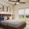 Bedroom with large window and ceiling fan at Heritage Grove apartment homes for rent in Broken Arrow, OK